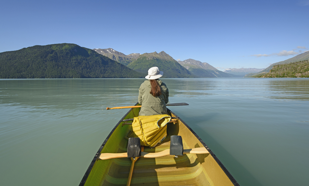 a woman sitting in a boat on the lake