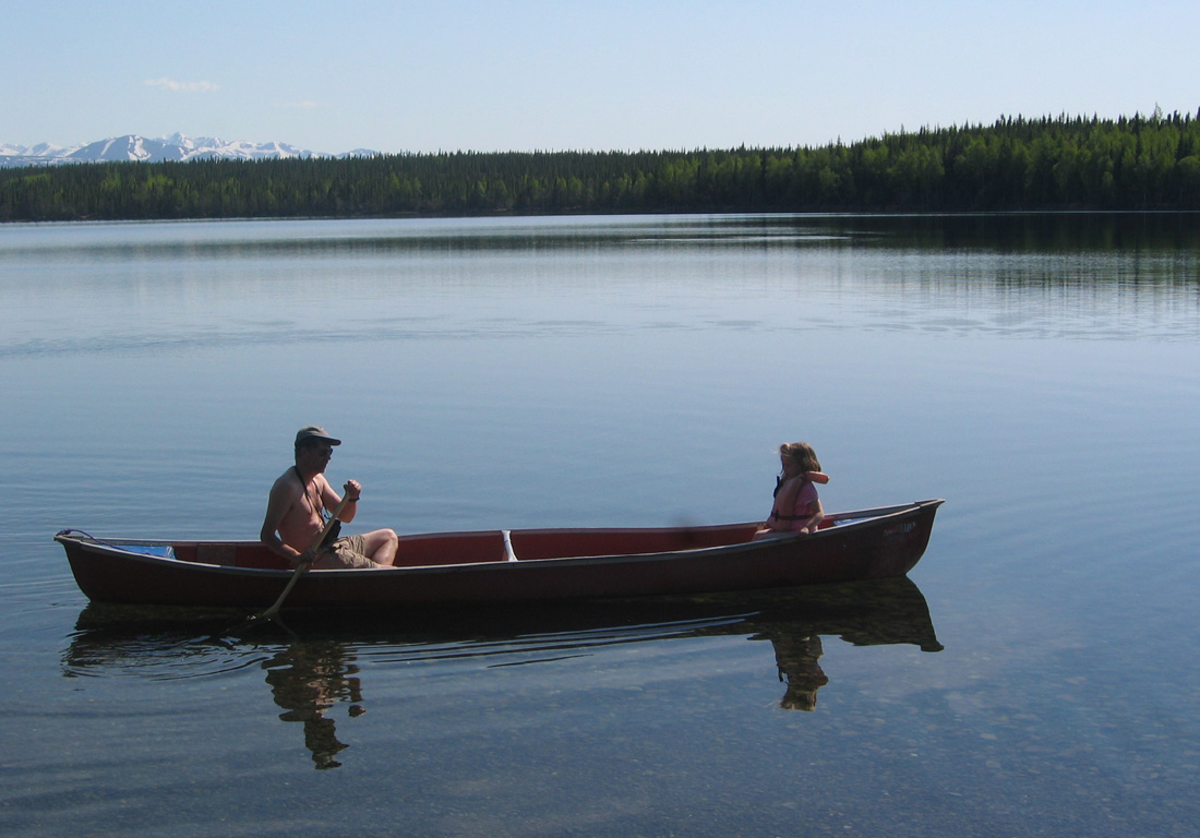 Fisherman with girl in boat on lake